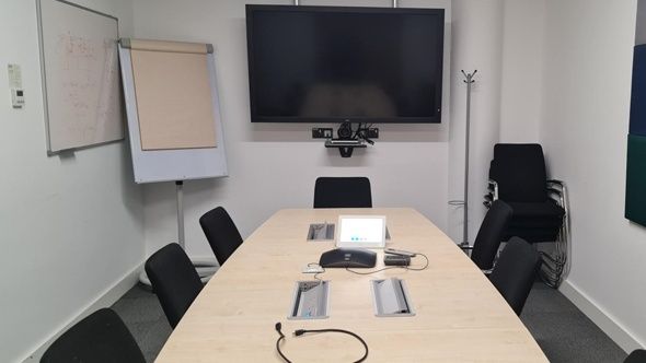 Mötesrum med videokonferensskärm och utrustning för hybridmöten